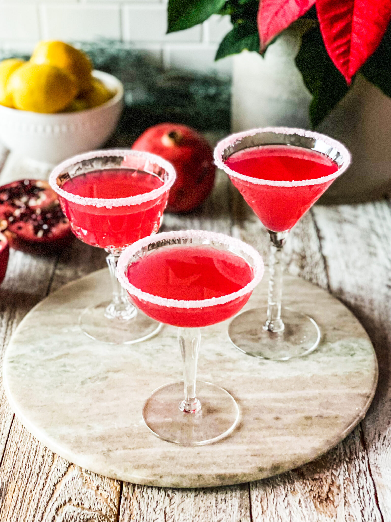 3 pomegranate lemon drop martinis with sugar dusted glasses