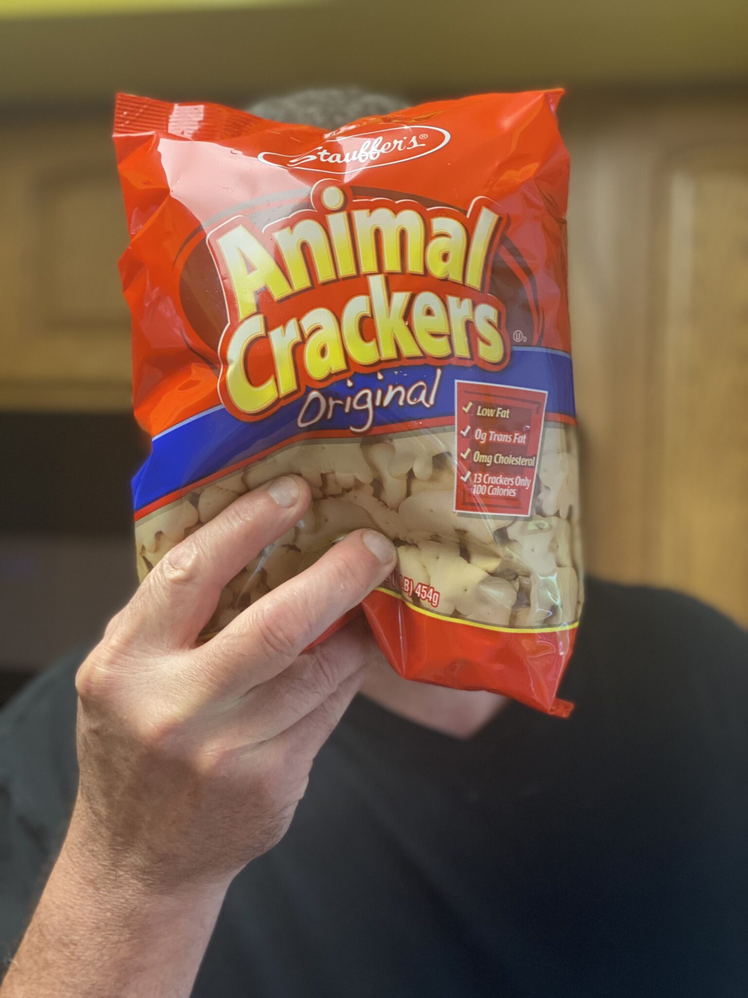a hand holding a bag of animal crackers