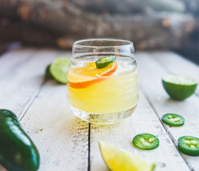 skinny spicy margarita with dried citrus wedge and jalapeño on top