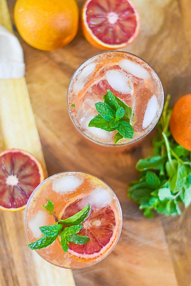 2 Bubbly blood orange bourbon smashes with mint and an orange