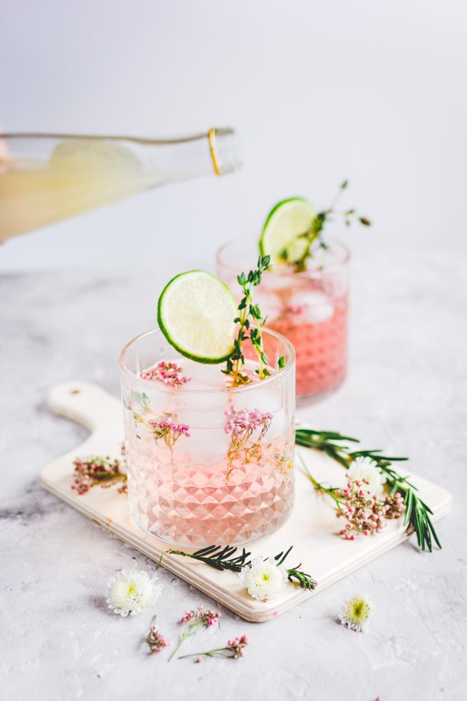 Pink vodka lemonade in 2 glasses with lime slices