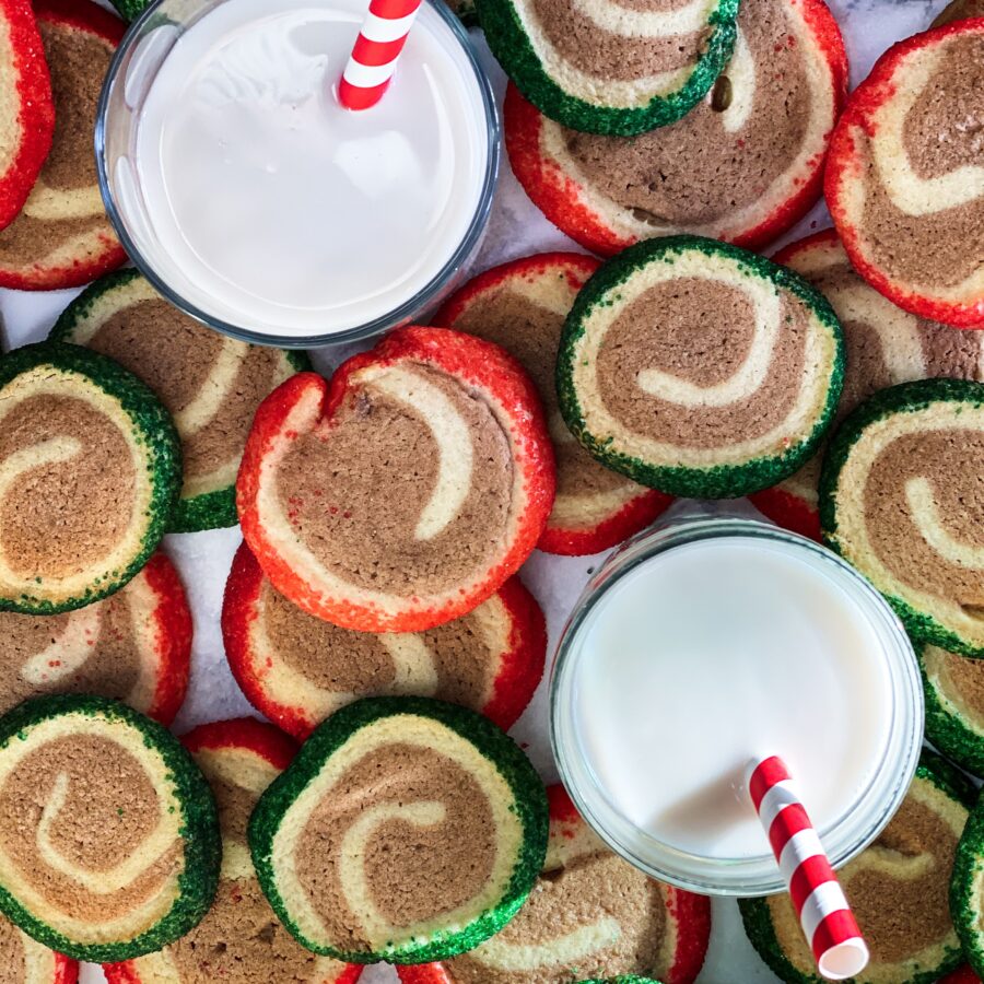 Red and green and chocolate cookies and milk with red and white straws