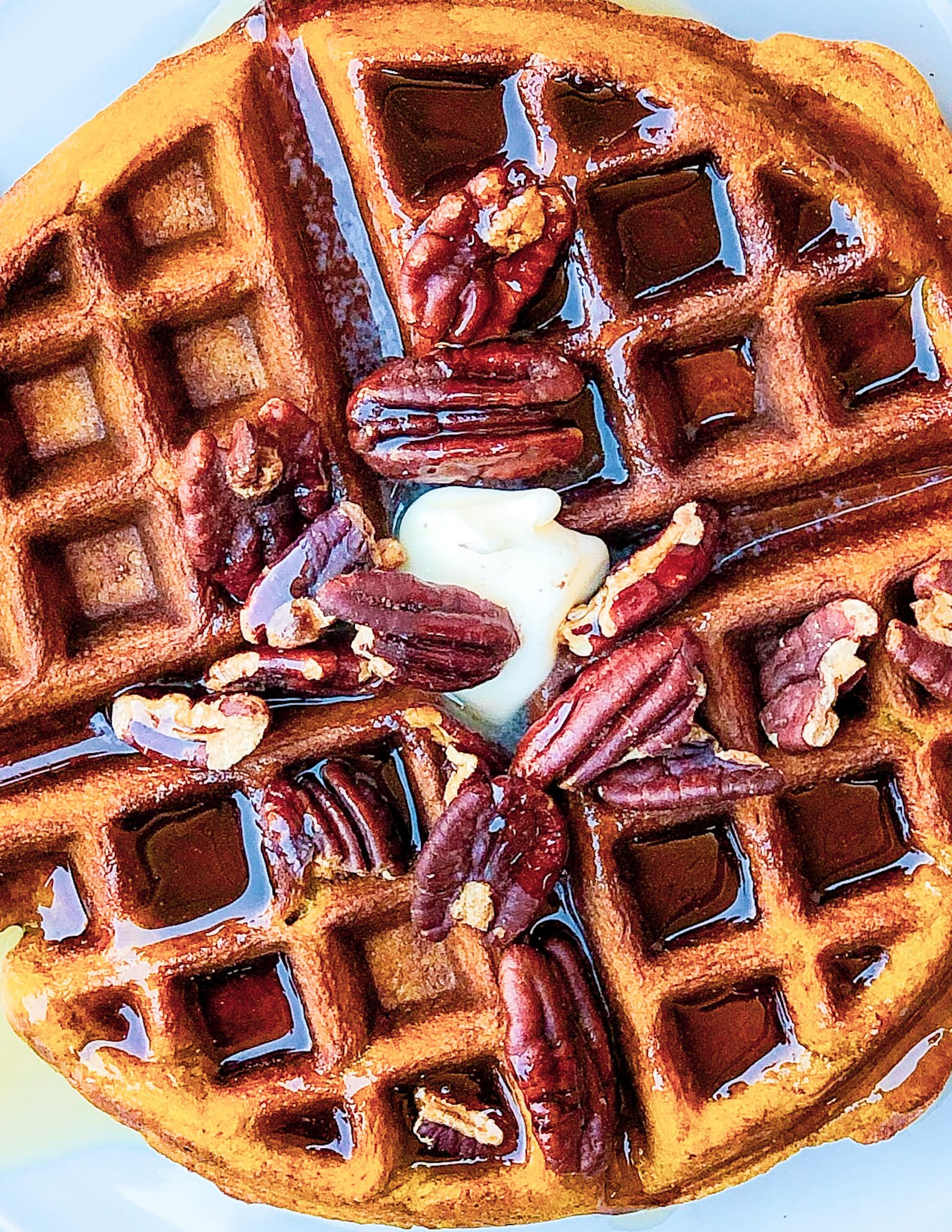 Waffle with butter, syrup, and roasted pecans