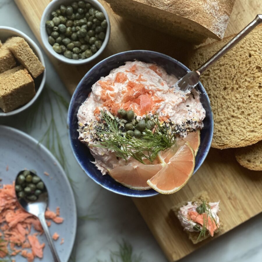 Smoked salmon spread in a bowl with capers on top and bread on the side