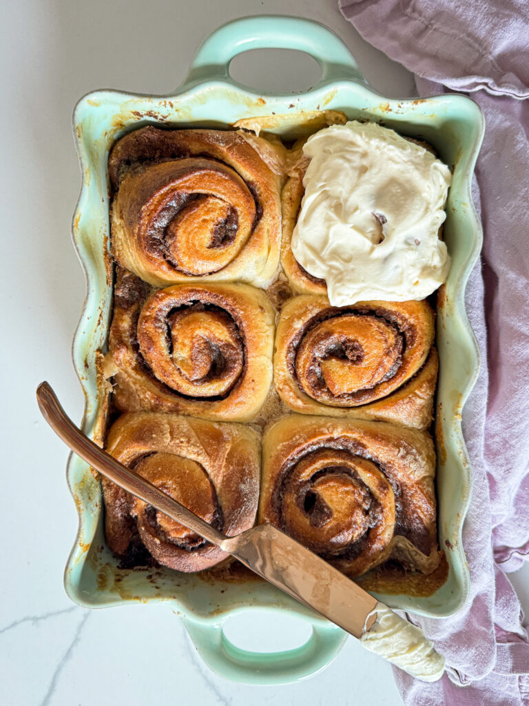 cinnamon rolls with cream cheese frosting and a knife