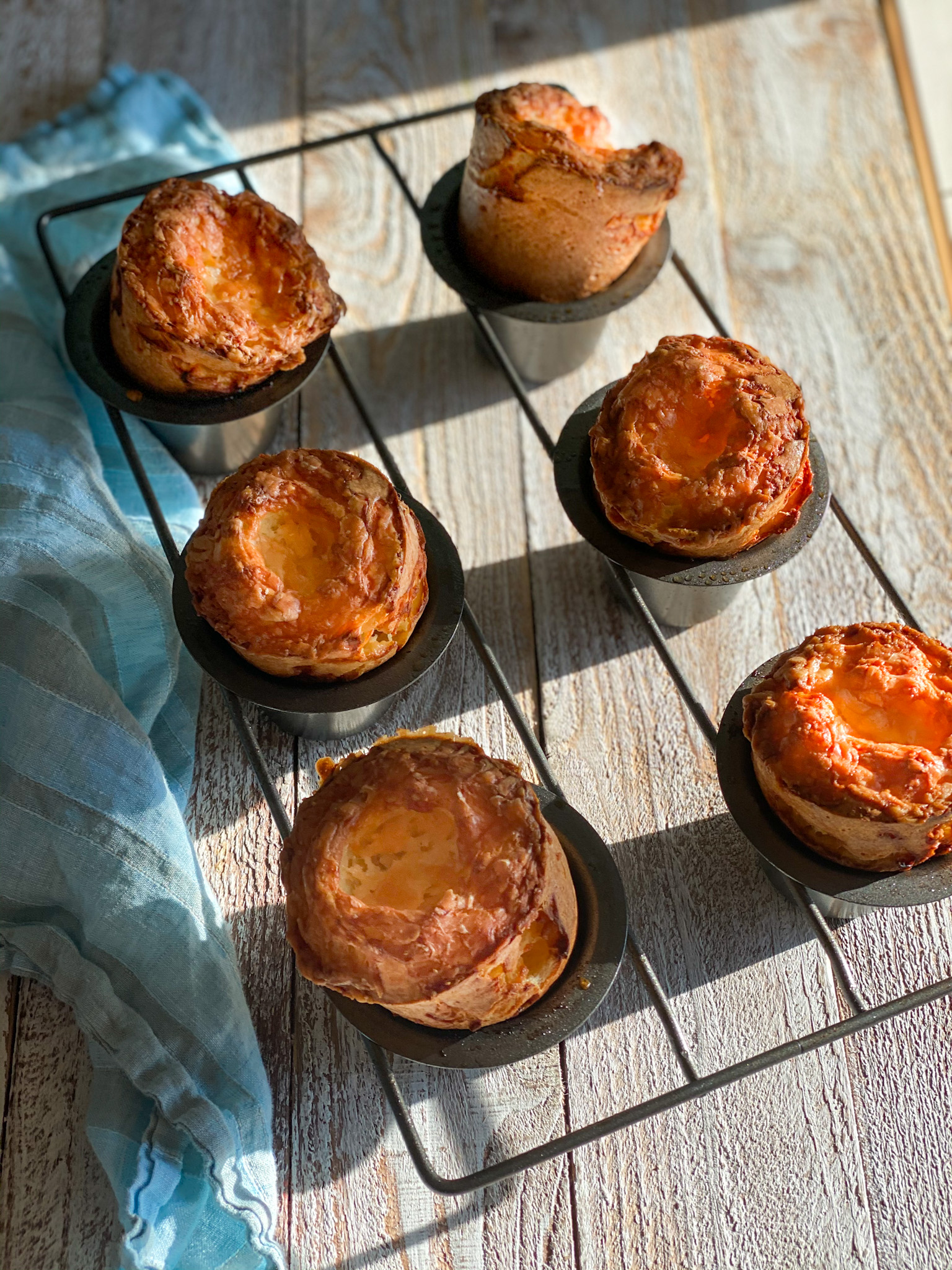 cheese popovers in a popover pan with a blue napkin