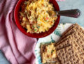 spicy pimento cheese in a bowl with crackers and a napkin
