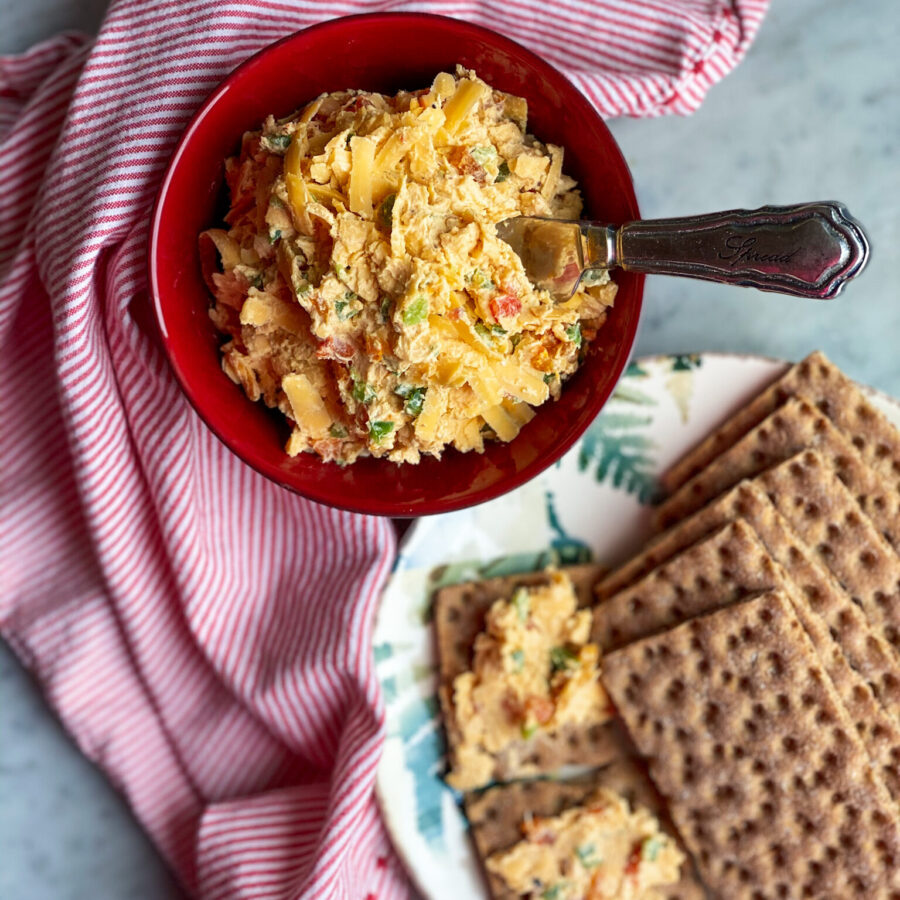 spicy pimento cheese in a bowl with crackers and a napkin