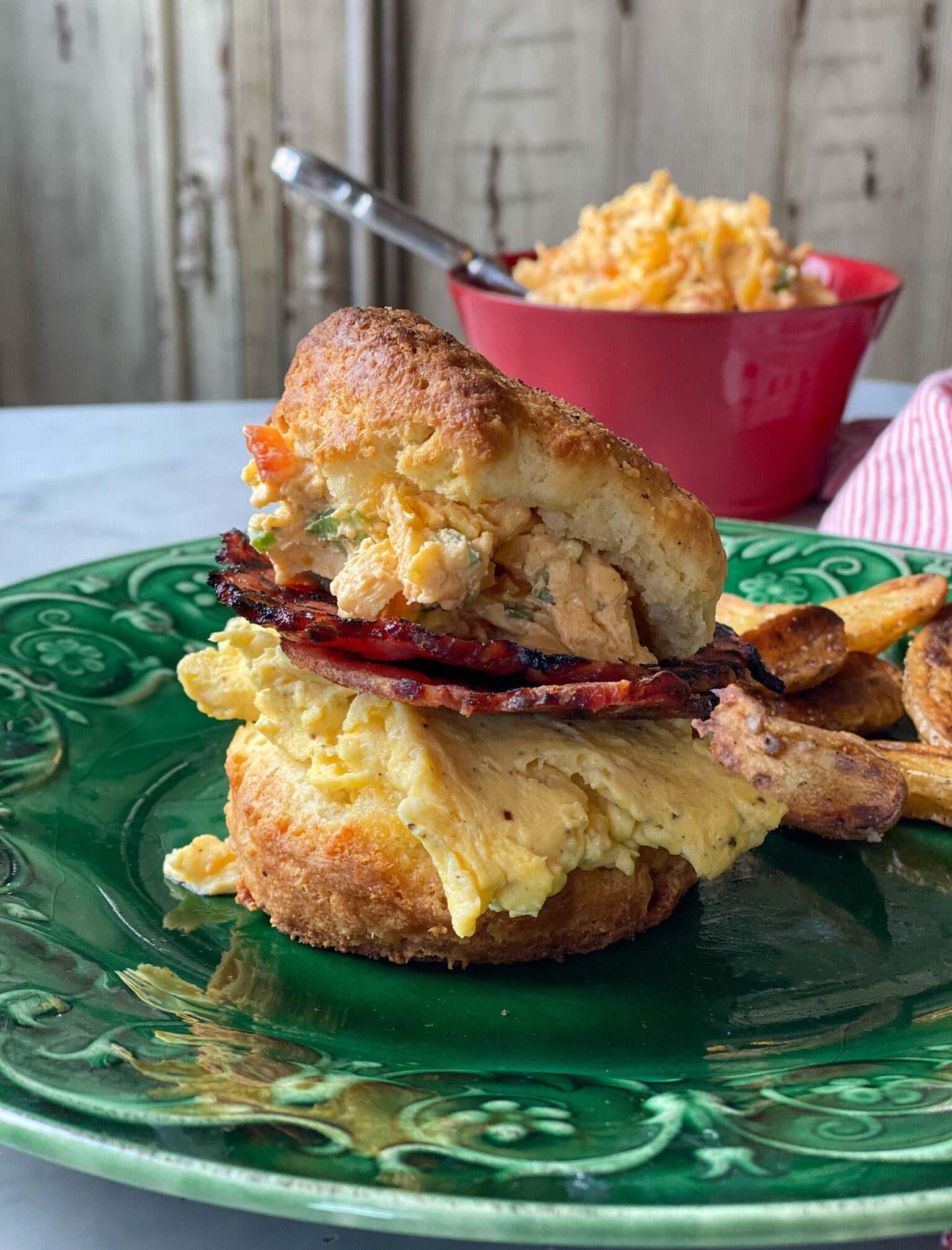 spicy pimento cheese on a biscuit with bacon and eggs