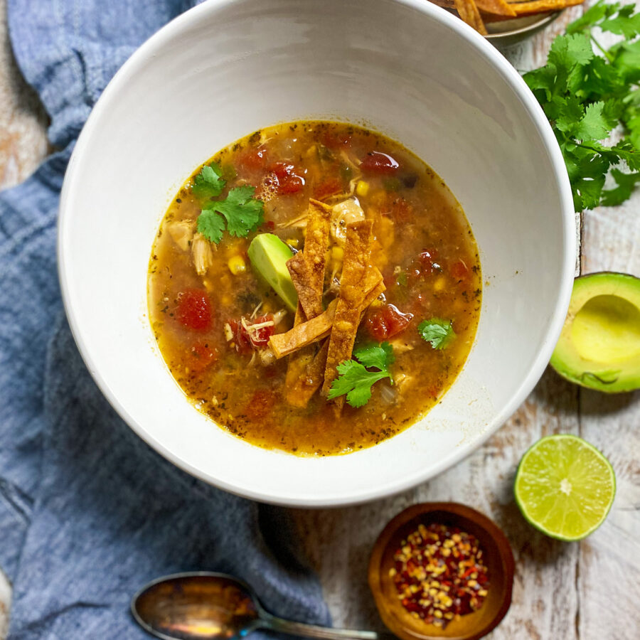 bowl of rotisserie chicken tortilla soup with avocado and lime