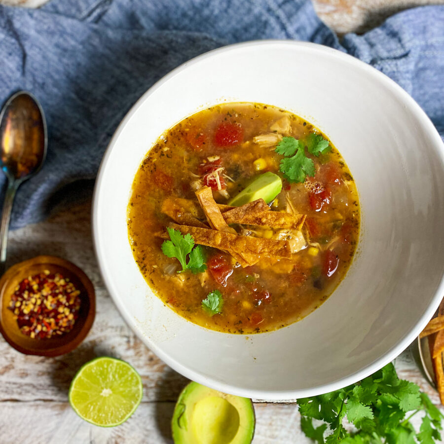 bowl of rotisserie chicken tortilla soup with avocado and lime