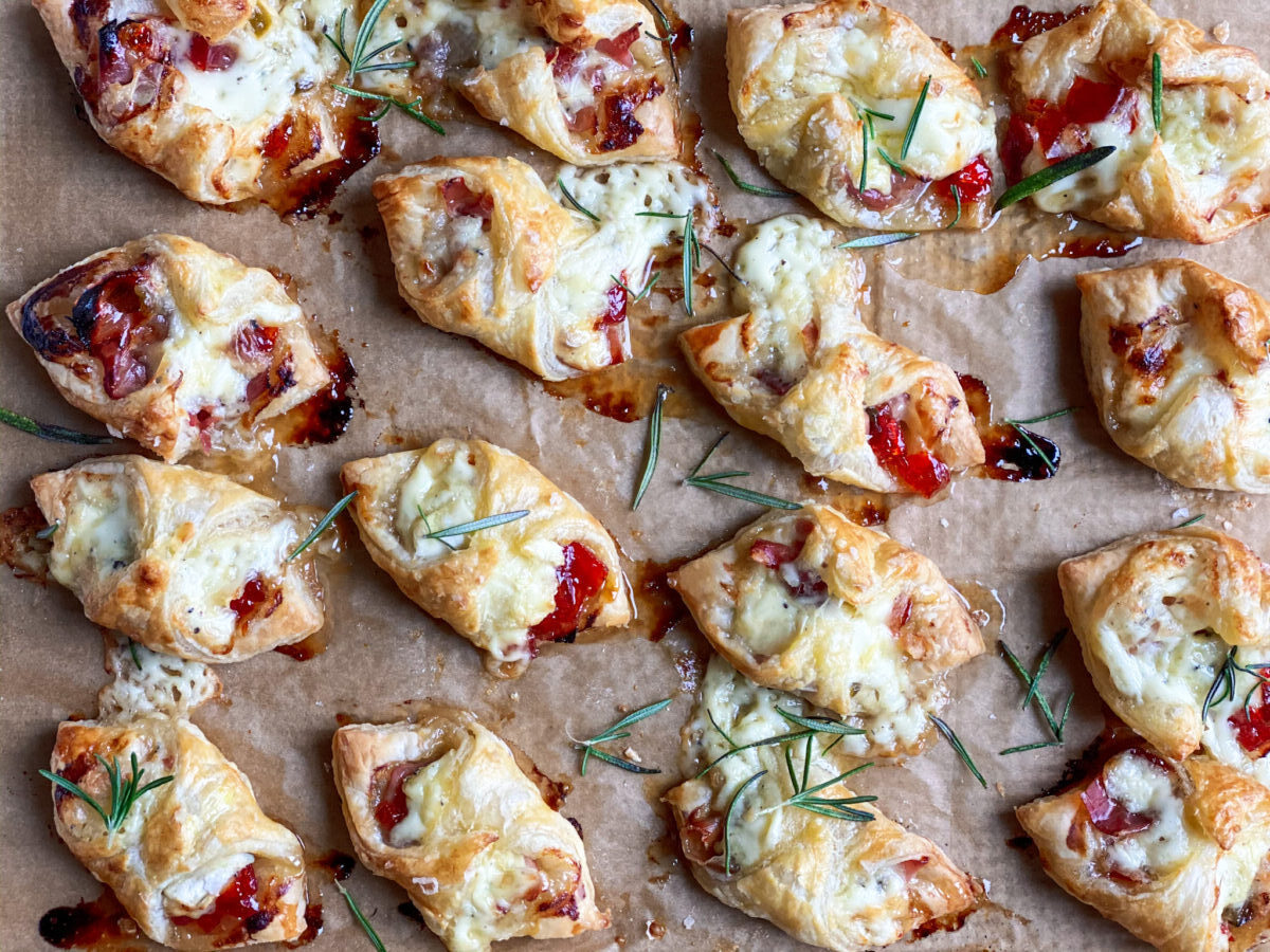 Baked brie with prosciutto and pepper jelly in puff pastry.
