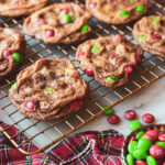 M&Ms in a bowl, plaid napkin, red and white ornament and chocolate chip cookies