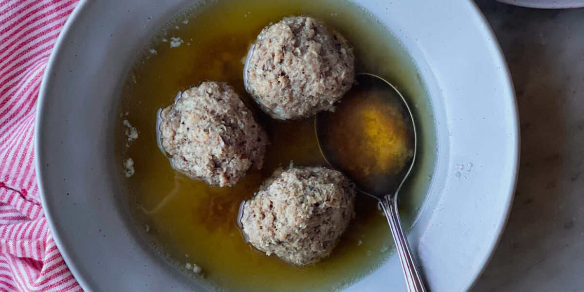 3 meatballs in broth with a roll