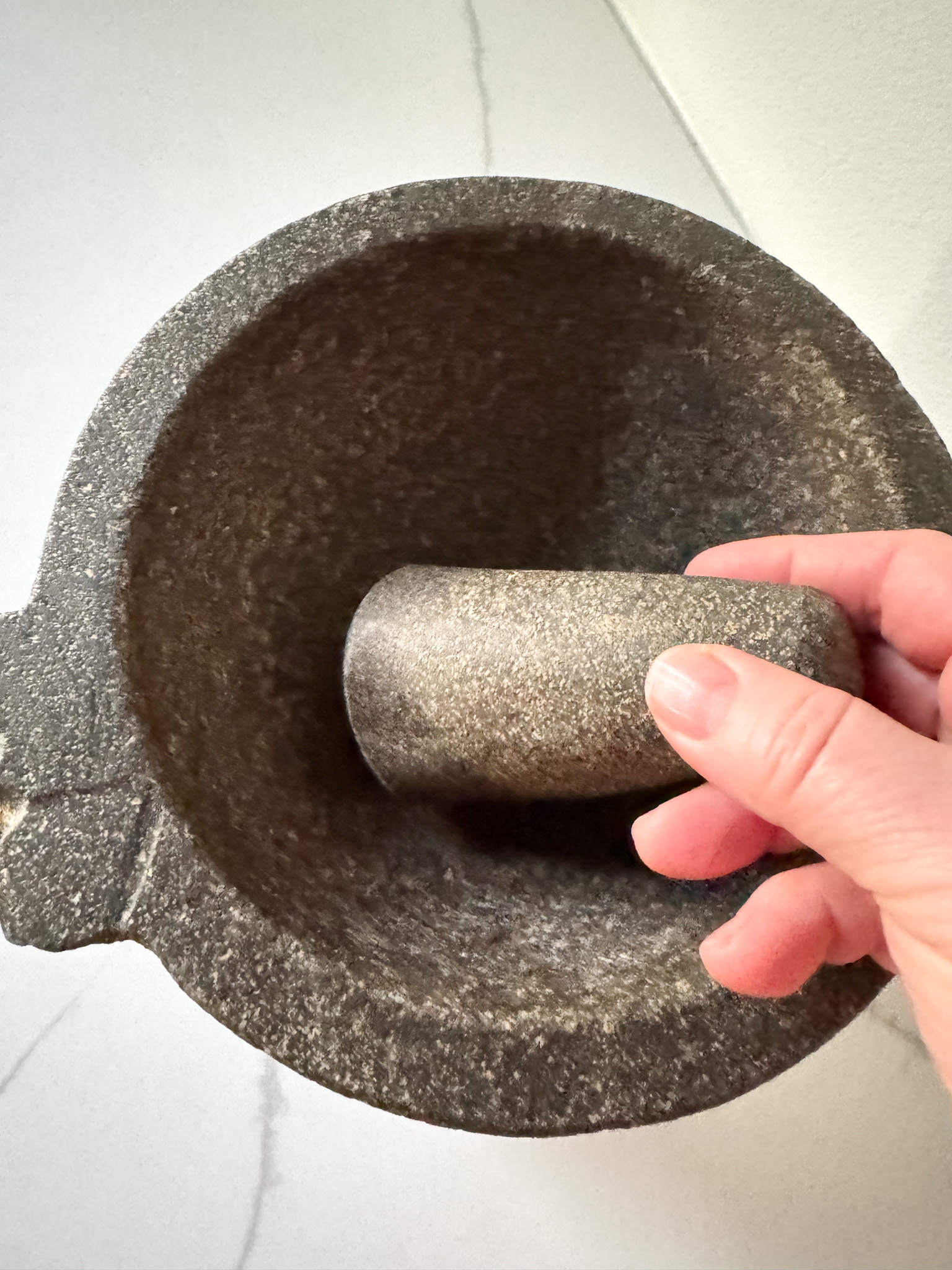 Hand holding a pistol of a molcajete