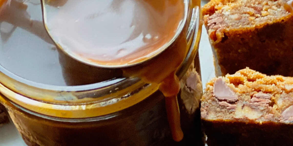A small mason jar with bourbon salted caramel sauce and blondies