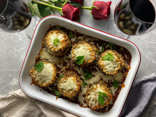 eggplant parm stacks in a pan with a wine and roses