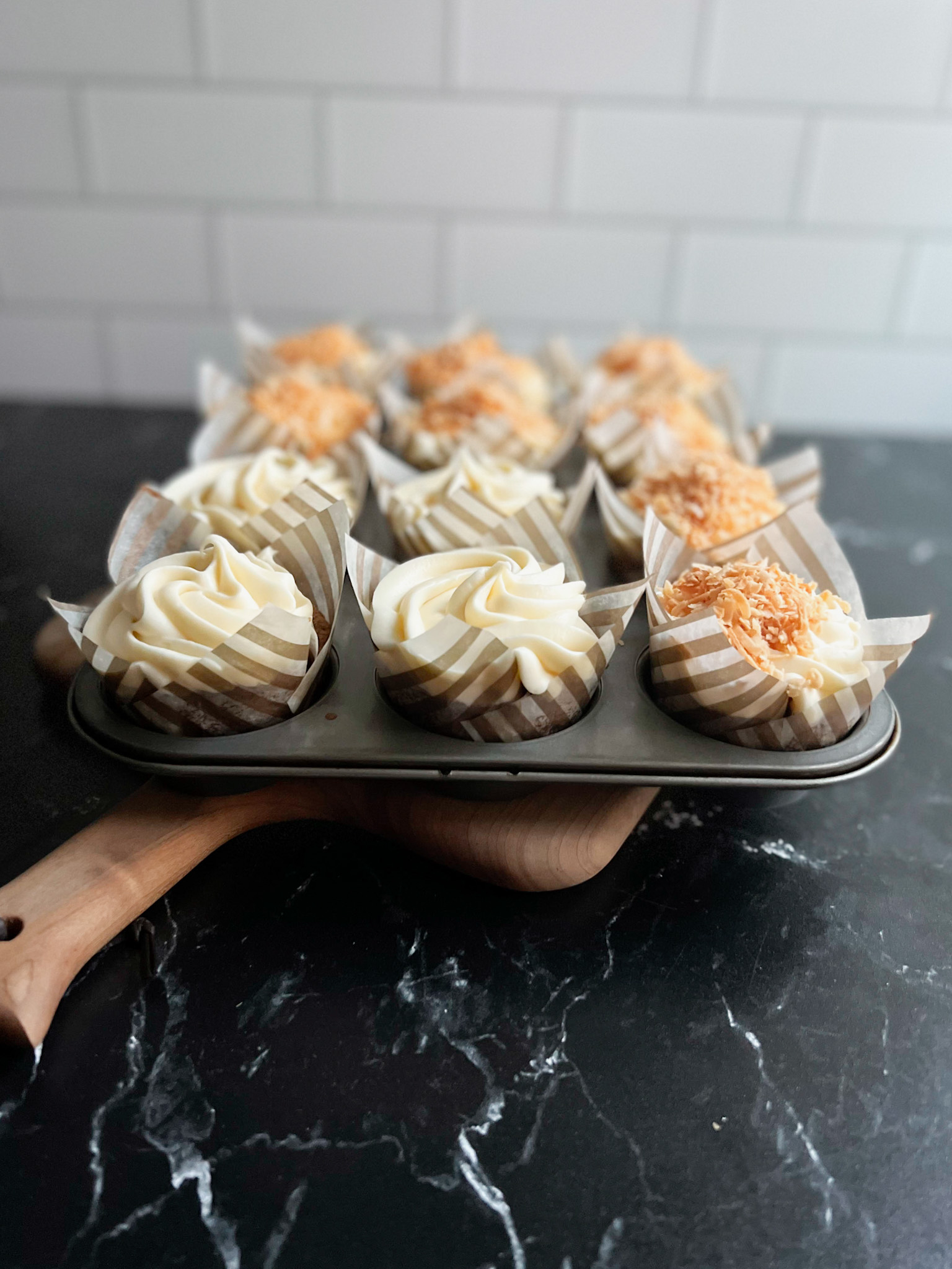 carrot cake cupcakes with toasted coconut on some