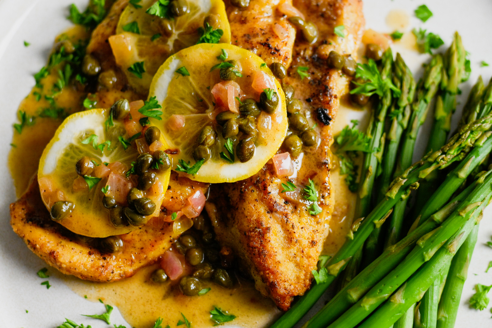Lemons and caper white wine sauce over chicken with asparagus