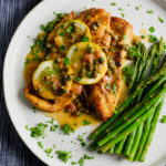 Lemon and caper white wine sauce over chicken with asparagus and hot pepper flakes