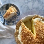 Coconut cream pie with a slice out of it on a plate