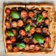 basil and tomatoes on a carmalized onion and tomato tart