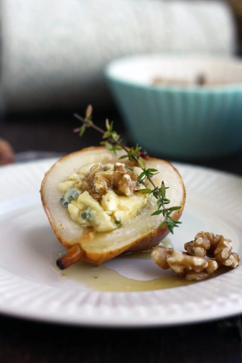 Bake pears and gorgonzola with honey on a plate with herbs