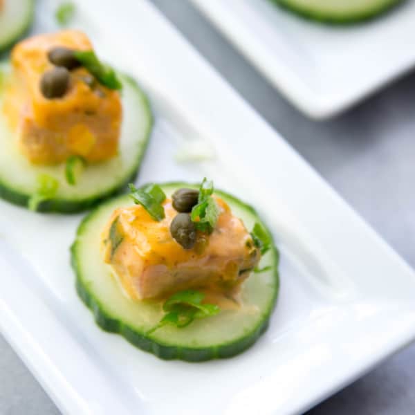 Dynamyte Salmon bites on cucumber on a white plate for appetizer & cocktail pairings
