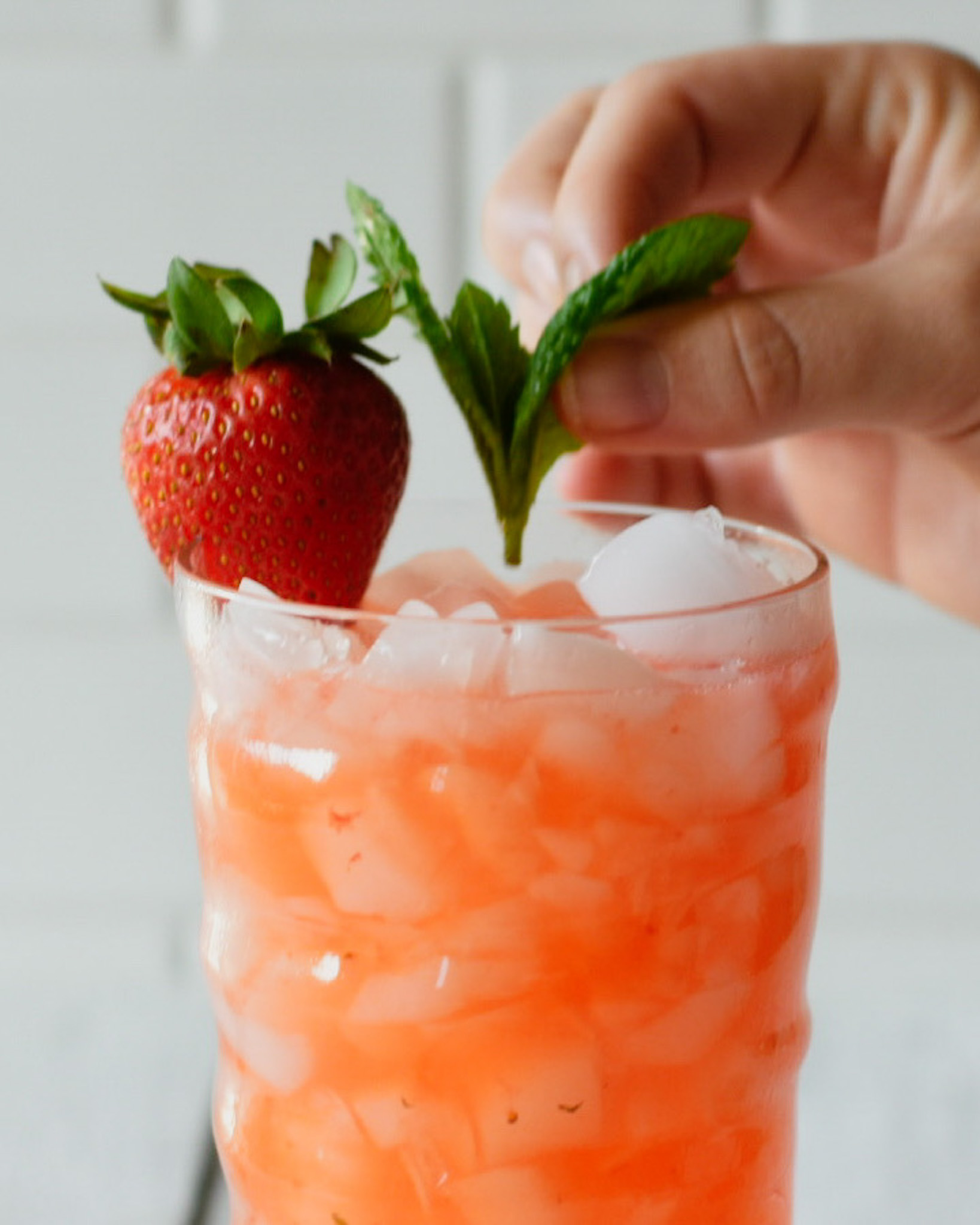 Mint being dropped into a strawberry moscow mule