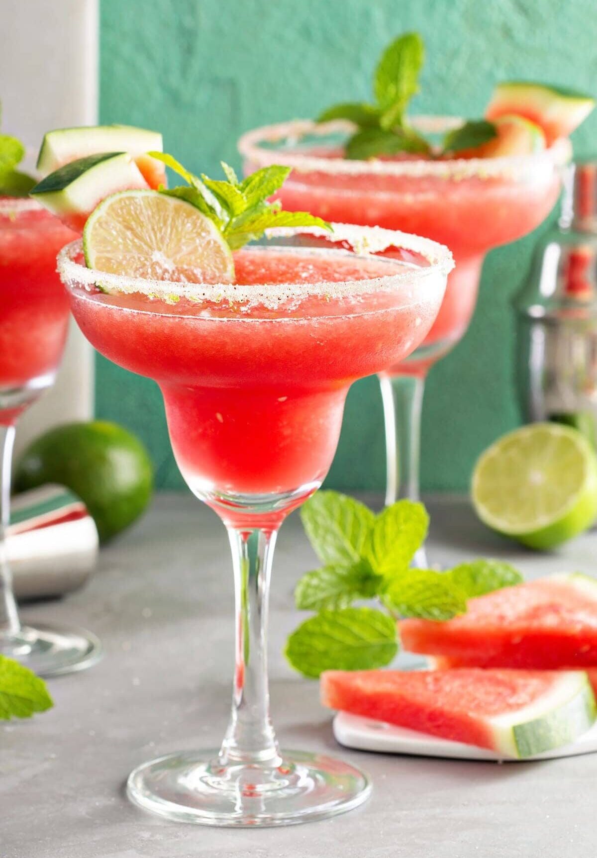 frozen watermellon margaritas in glasses with limes