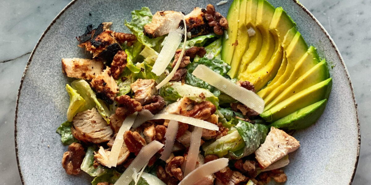 Caesar salad with avocado and walnuts and chicken