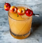 Summer Sea Breeze drink in a crystal glass with 4 cherries as a garnish.