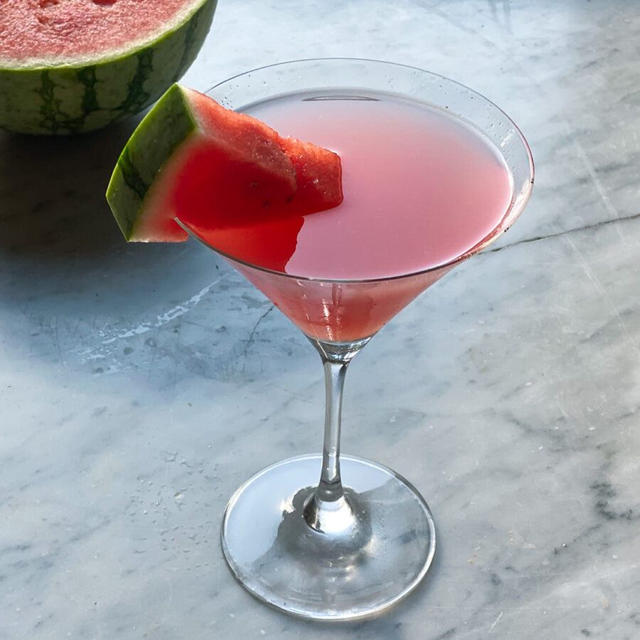 watermelon martini with watermelon wedge and watermelon in backround