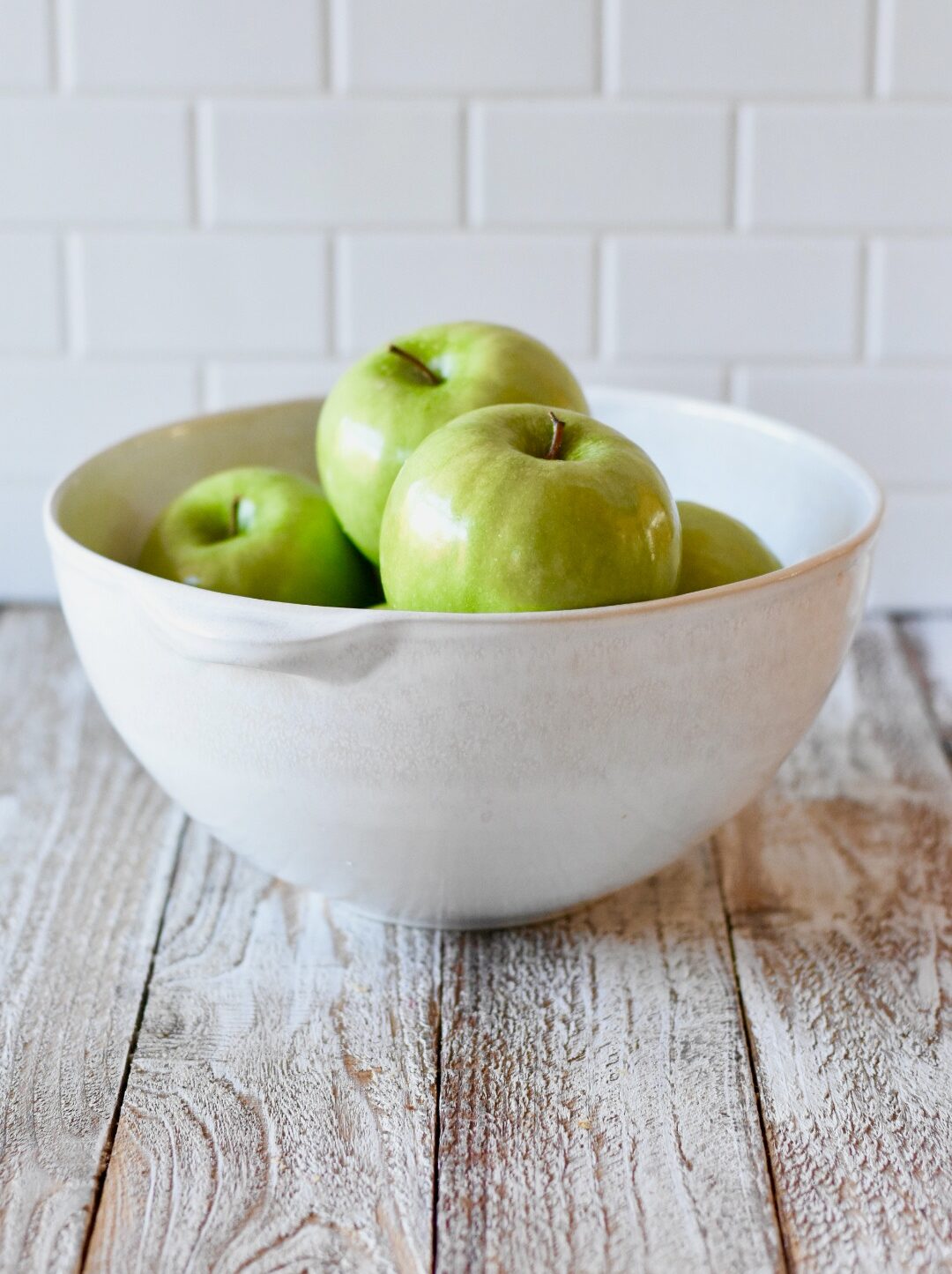 white bowl of granny smith apples