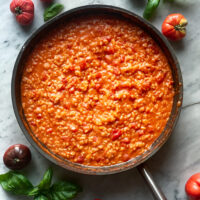 Tomato Risotto in pan with tomatoes around the pan