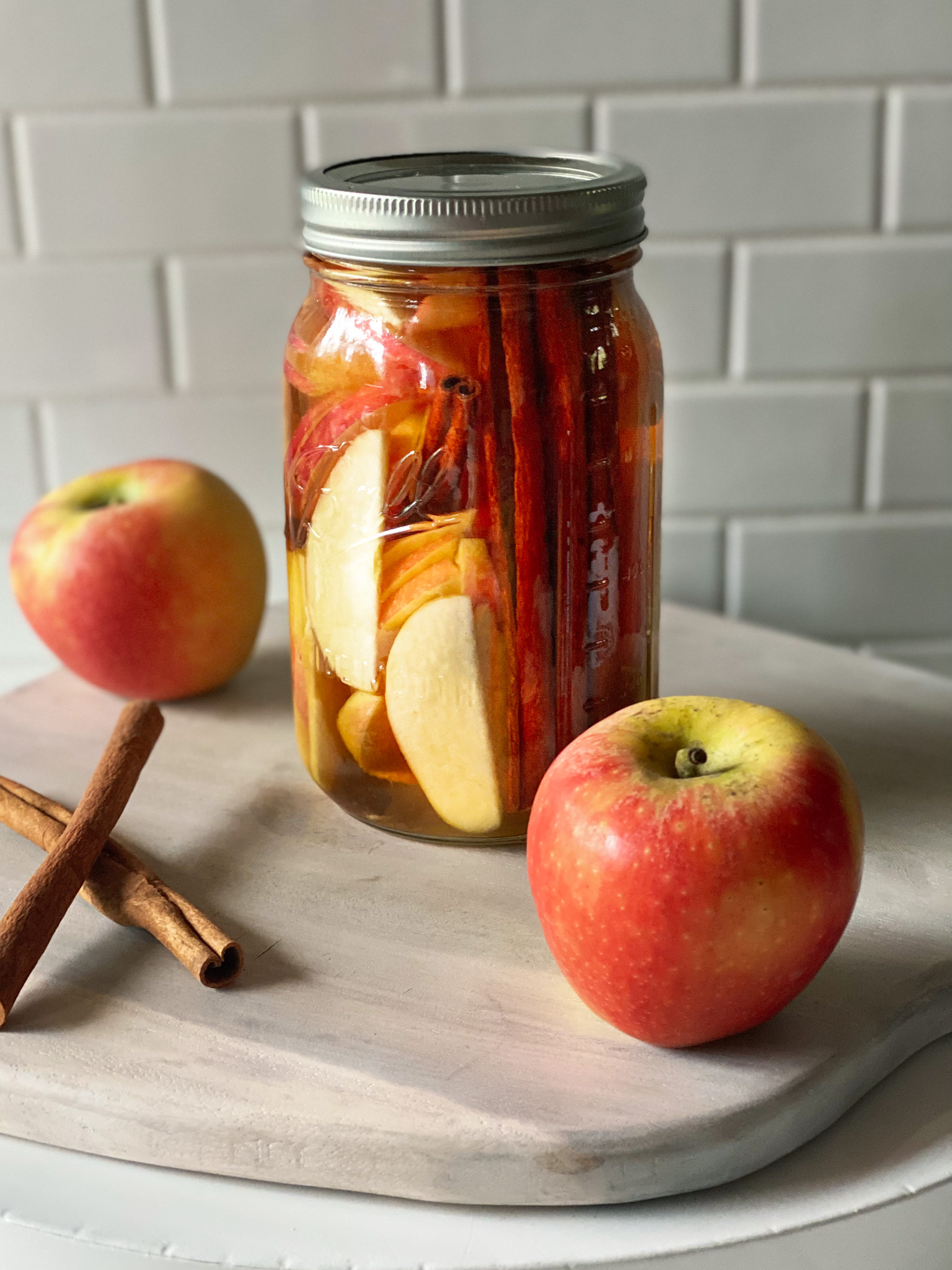 bourbon in a mason jar with apples and cinnamon sticks