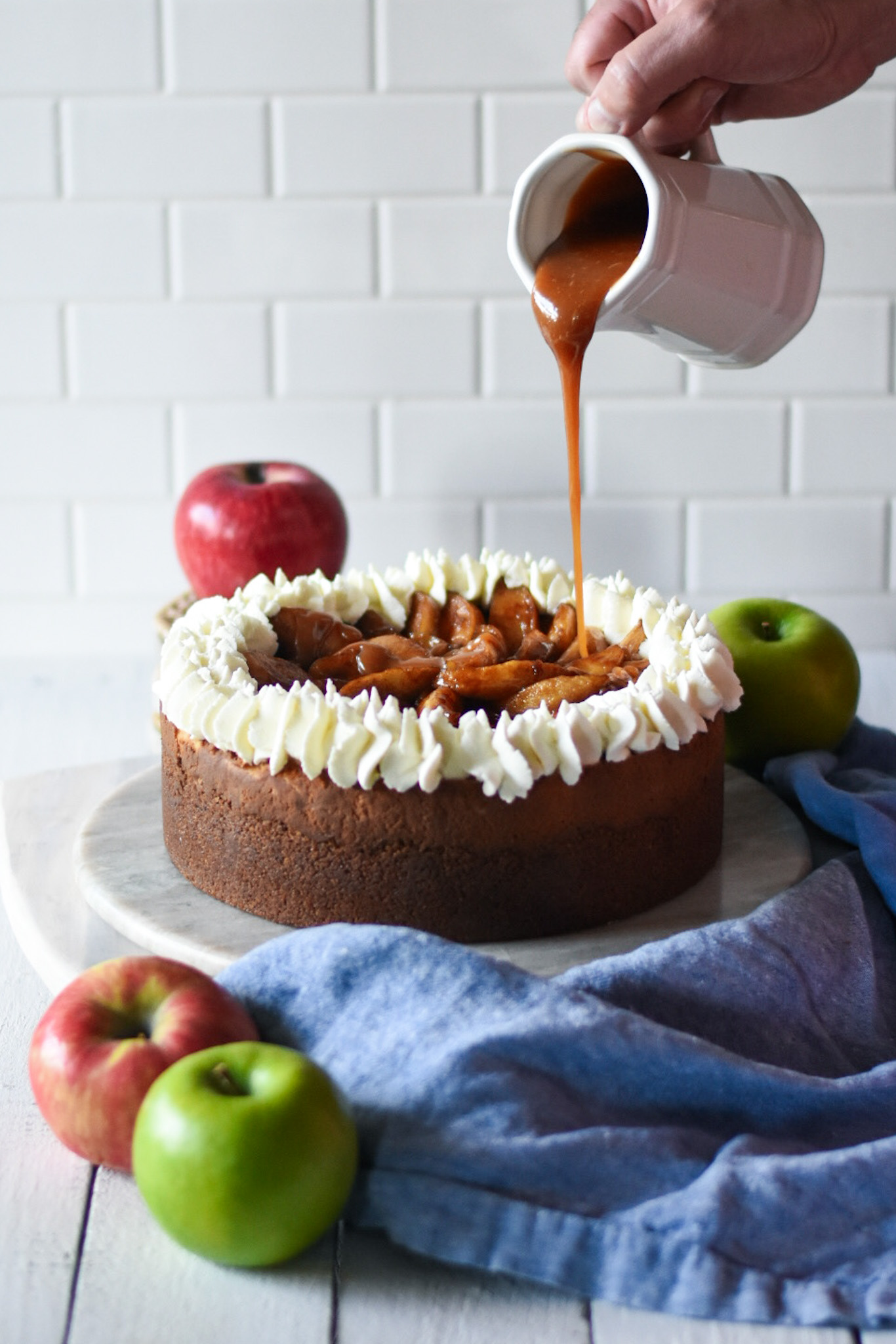 caramel apple cheesecake with caramel being poured on top