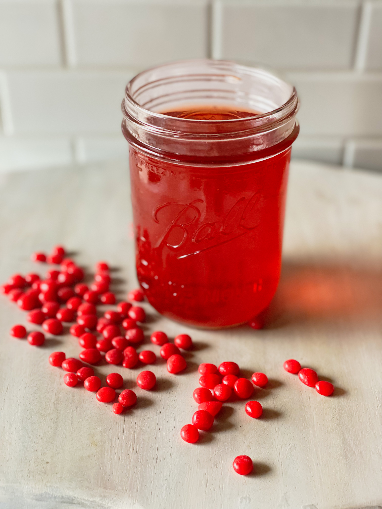 Mason jar of homemade fireball bourbon and some red hot candies