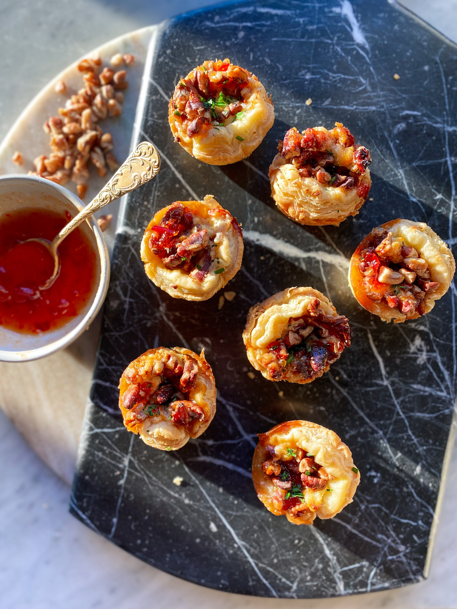 sweet and salty boursin and pecan cheese tarts on a tray with jelly