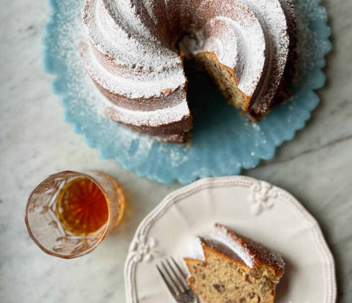 bourbon butter pecan cake with a slice and a glass of bourbon