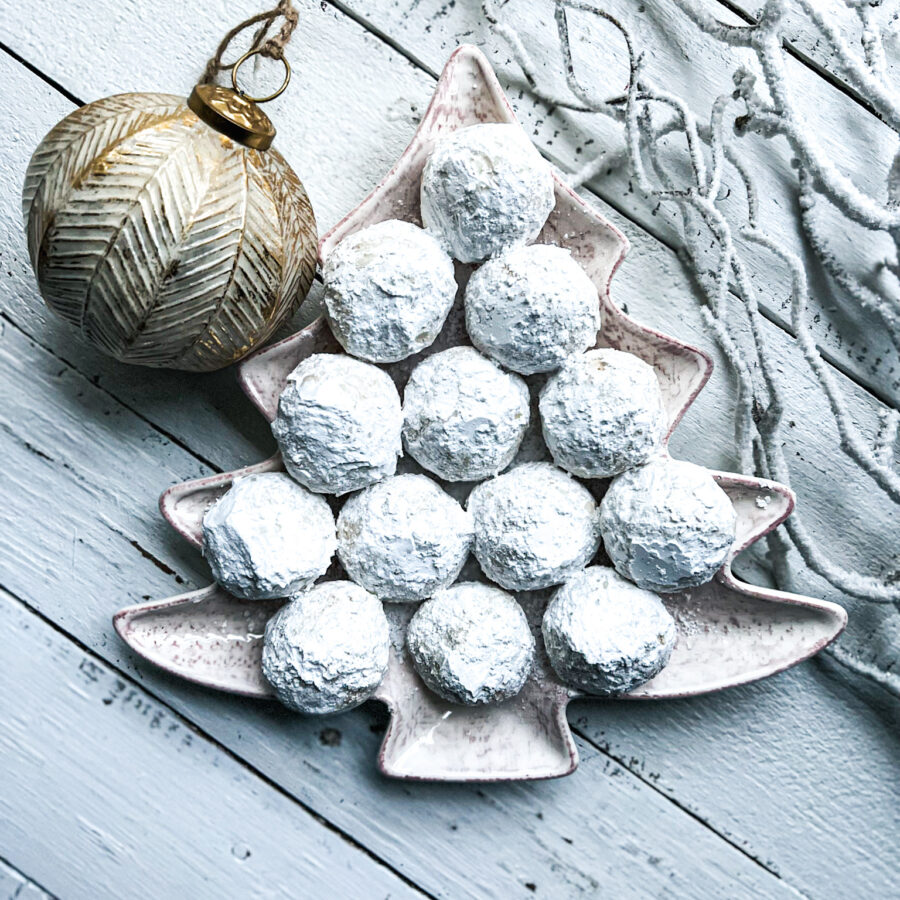 snowball cookies in a Christmas tree shaped platter with an ornament