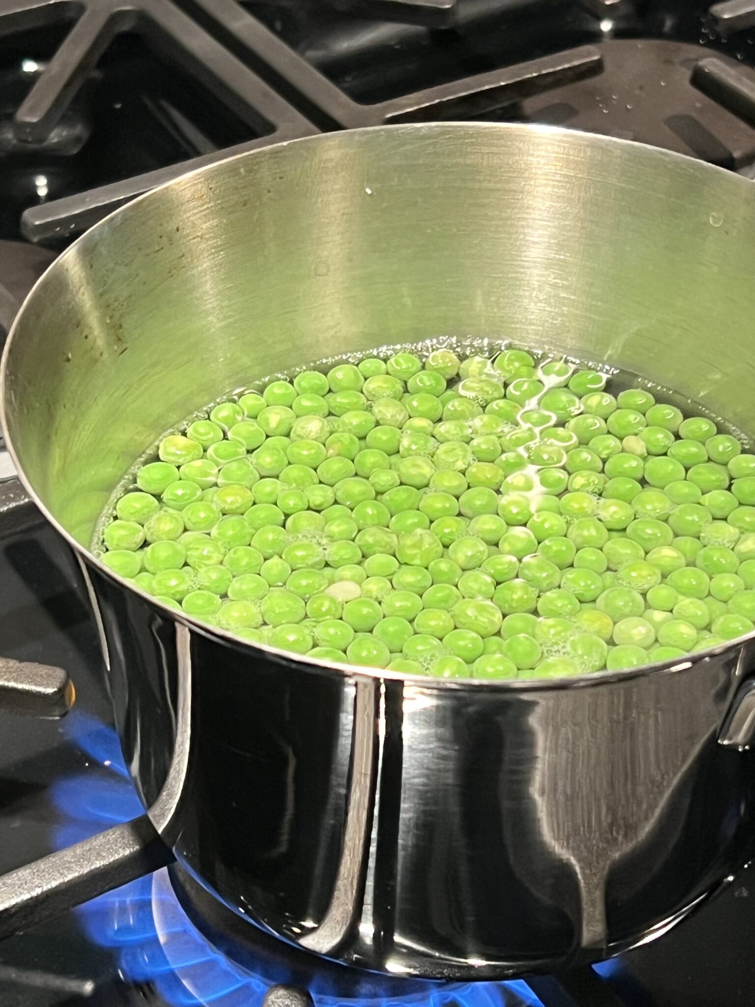 fresh peas in a pot boiling