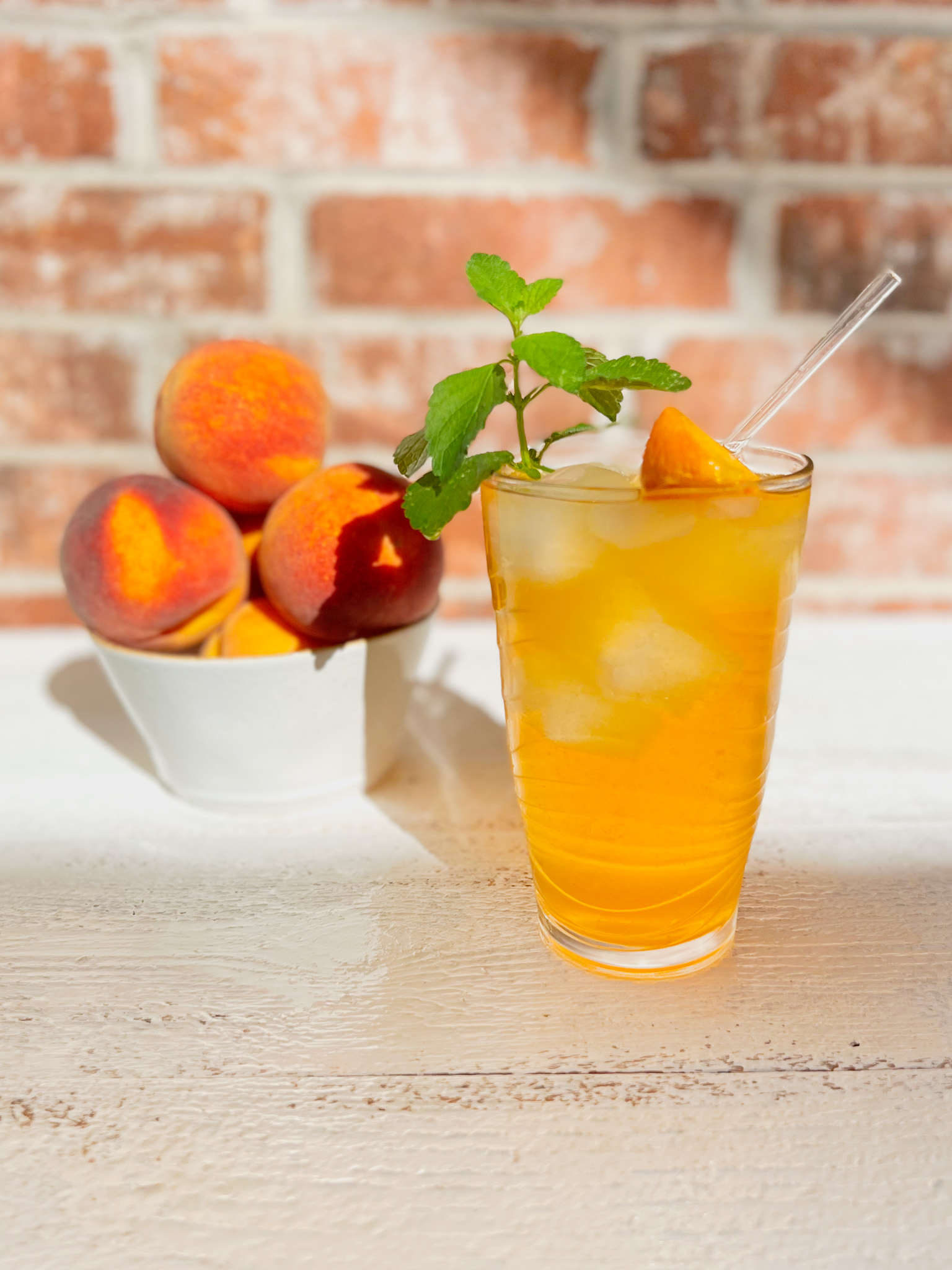 iced peach green tea with mint and a bowl of peaches