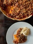 peach crumble pie with a slice on plate