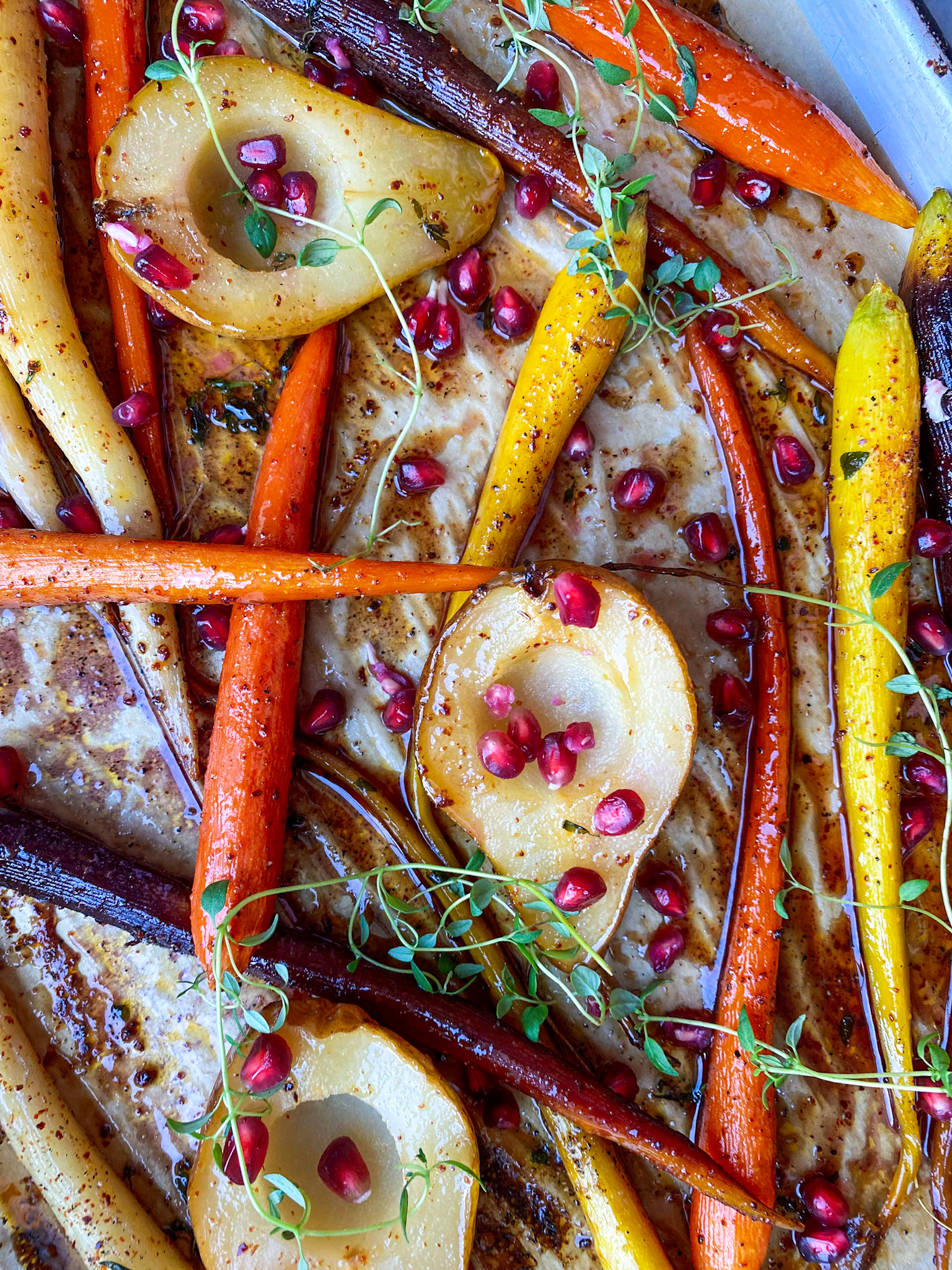 carrots and pears on a sheet pan with herbs