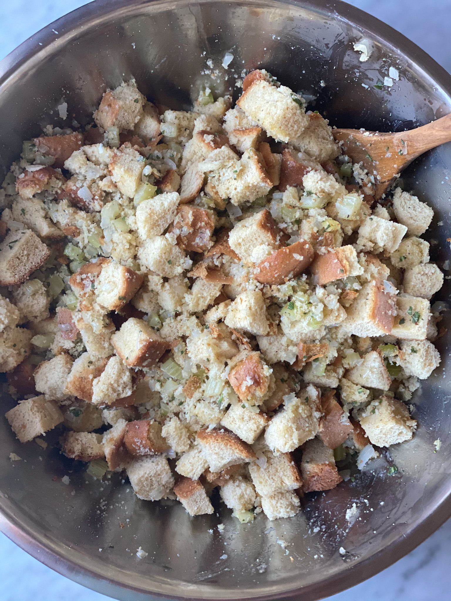 Raw stuffing in a bowl with seasoning on it