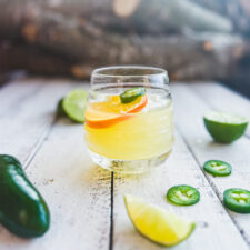 skinny spicy margarita with dried citrus wedge and jalapeño on top