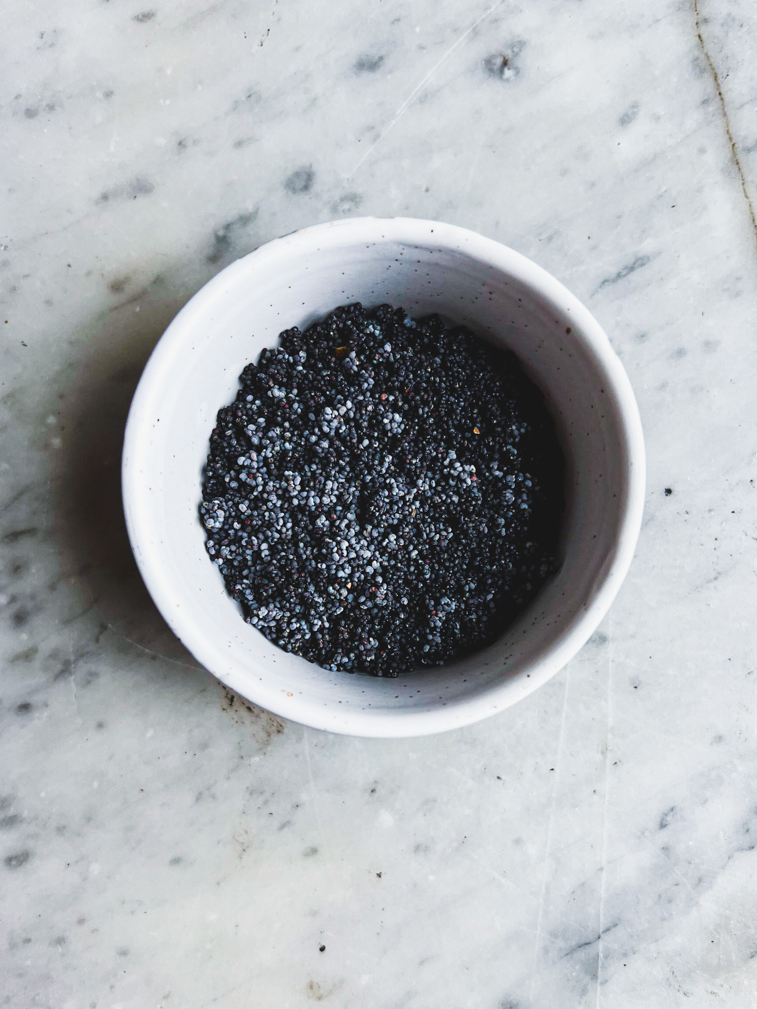 a white bowl with poppy seeds