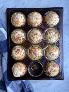 bacon cheese muffins in a muffin pan with one missing
