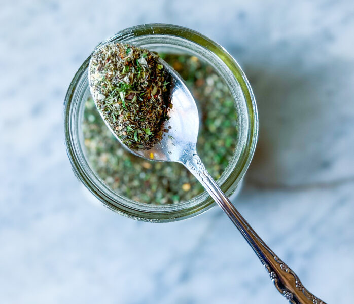 Greek Spice blend in a jar with a spoon of spice seasoning